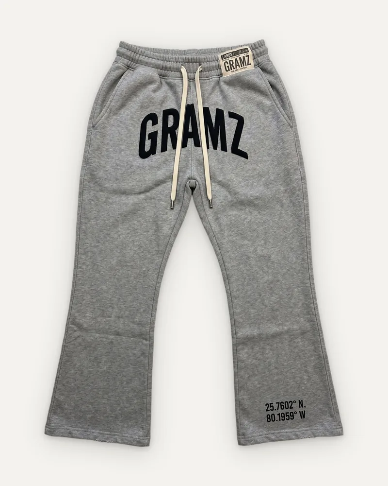 Design rendering: heather grey flared sweatpants with a black arched GRAMZ print and Miami coordinates at the hem