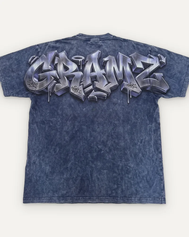 Design rendering: back of a washed indigo tee with a large chrome graffiti-style GRAMZ print across the shoulders