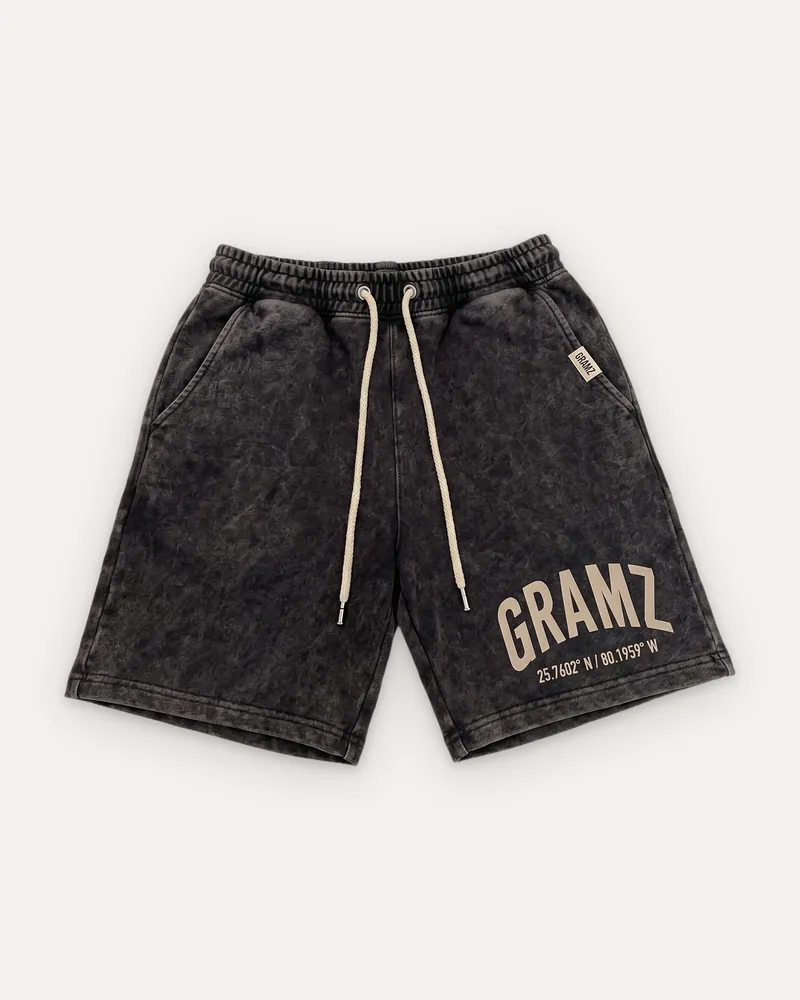 Design rendering: washed charcoal sweat shorts with a sand arched GRAMZ print and Miami coordinates at the left leg